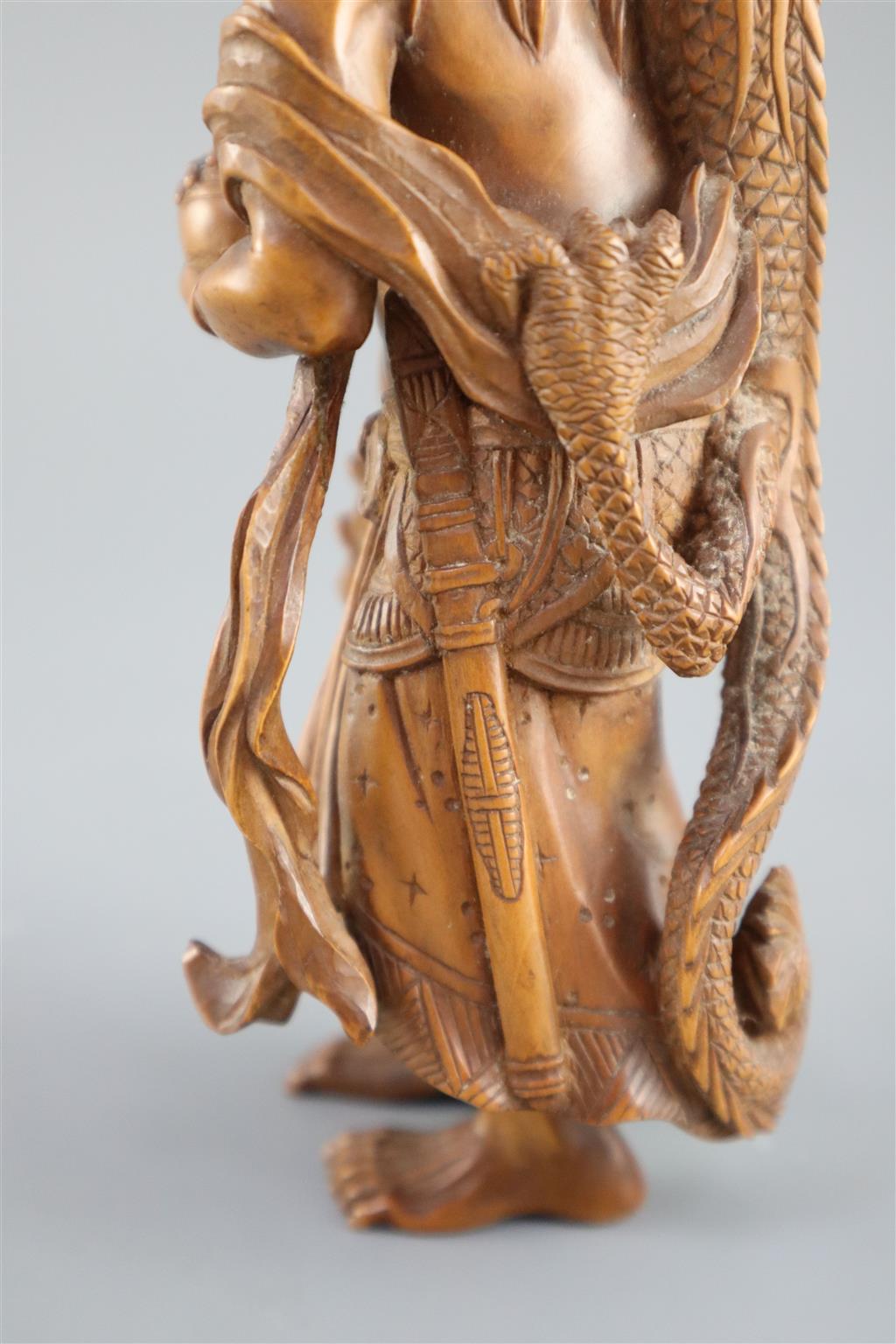 A fine Japanese boxwood okimono of the Sennin Handaka Sonja with a dragon clambering on his back, 19th century, signed Masakazu, 16.5cm